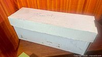 Closed white long comic box with handwritten label