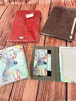 Four cases: red embossed, brown folio, two deer print; all in plastic