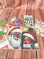 Overview of entire lot showing burlap tag packs, vinyl letters pack, bag of stampers, plastic gift bags, gift label sheets