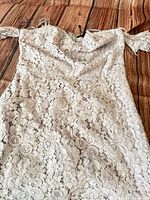 Full view white lace off-shoulder dress laid flat