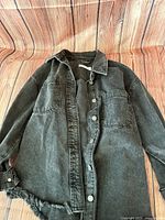 Full view of washed black denim shacket laid flat