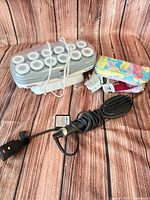 Full lot showing hot roller unit with rollers and clips, cosmetic pouch, ghd brush