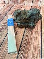 Incense tin beside carved wooden figurine