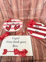 Three wood Valentine’s wall signs displayed together