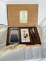 Box opened showing board, tray, utensils and paperwork