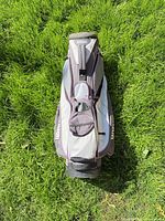 Front view of Wilson gray and pink golf cart bag on grass