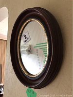 Frontal view of the 11x13 oval mirror with wooden frame and gold accent inner trim.