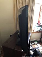 Side view of a Samsung television showing screen thickness and stand base.