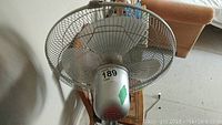Silver adjustable pedestal Sylvania fan with metal cage, three blades, and control panel on stand