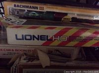 Photo showing stacked boxes with Lionel HO product train accessories box on top and Bachmann HO train engine box beneath.
