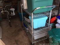 Metal wire rolling cart with three shelves and multiple plastic storage bins in blue, gray, and green colors.