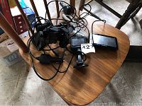 Photo showing Garmin devices and cables on wooden chair including GPS and dash cam units.