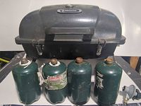 Front view of grill with four propane canisters