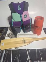 Group view: life jacket, paddle, flare canister, two ropes