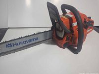 Left side view showing full chainsaw with bar and chain
