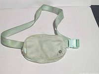 Front view of mint Lululemon fanny pack showing buckle and logo