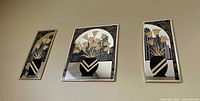 Frontal view of all three mirrored plaques on wall