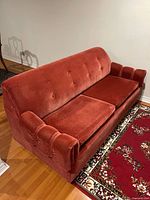 Full view of rust corduroy sofa, cushions in place