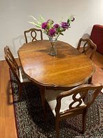 Oval wooden dining table with four matching chairs