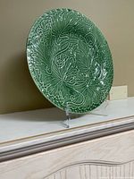 green relief leaf motif plate on clear stand