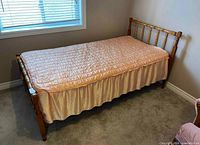 Wooden twin bed frame assembled with bedspread