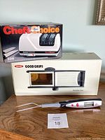 Boxed Chef'sChoice knife sharpener, boxed OXO mandoline slicer, digital thermometer fork