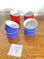 All eight ramekins stacked by color on table