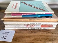 Stack of six vintage sewing and textile paperbacks showing spines