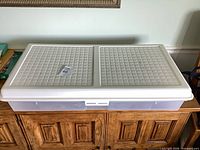 Closed storage box showing white textured lid and clear sides