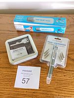 Three packaged items: Swiss+Tech tin, Point Relief massager box, earthPad screwdriver blister