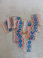 All 12 sealed Cracker Jack Toy Surprise envelopes spread out on carpet