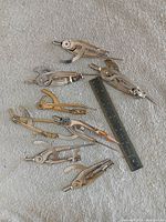 Group shot showing eight wing compasses and 6 in. steel ruler on fabric surface