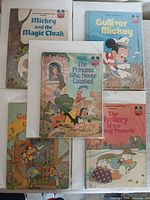 Group shot of five Disney Wonderful World of Reading hardcover books in plastic sleeves