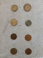 Eight coins laid out in four rows for overview