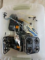 Overview of bin with two Lumo Stunt drones, two Sky Rider helicopters and controllers