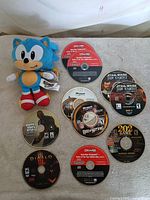 Overview of Sonic plush and eight loose game discs
