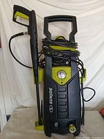 Full view of pressure washer with hose and spray gun attached