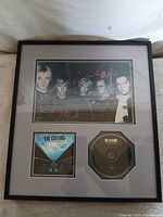 Front view of framed memorabilia showing photo, album art, and CD
