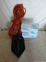 Lot overview showing folding shovel, extension cord, two face mask boxes