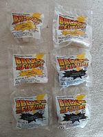 Six sealed 1991 McDonald’s Back to the Future Happy Meal toys (three Marty’s Hoverboard, three Einstein’s Traveling Train)