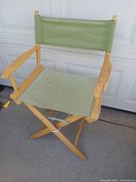 Front view of wood and sage green canvas folding director’s chair