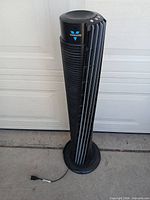 Full view of Vornado tower fan standing on circular base