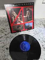 Front of album sleeve showing title and artwork, vinyl record displayed below