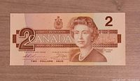 Obverse of 1986 Canadian $2 note showing Queen Elizabeth II, coat of arms, Ottawa 1986, signatures