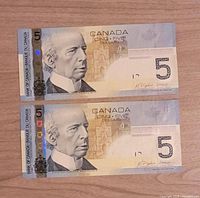 Obverse of both 2004 $5 notes showing Laurier portrait and serials