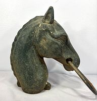 Left side view of cast iron horse head topper with ring