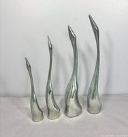 Front view of all four aluminum crane sculptures
