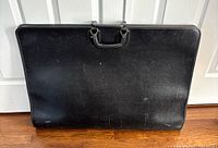 Front view of black portfolio case showing overall size and handles