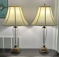 Front view of both matching crystal and brass table lamps with shades