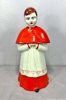 Front view of ceramic choir boy decanter showing hand-painted details